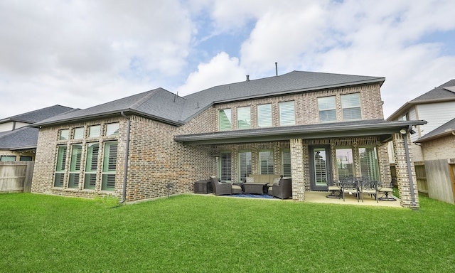 rear view of house featuring brick siding, a lawn, outdoor lounge area, and fence