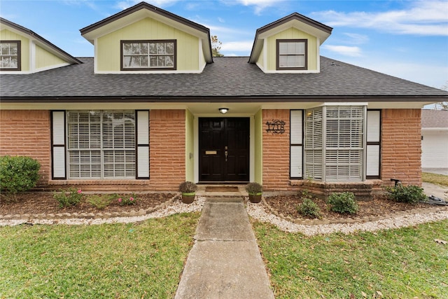 view of front facade featuring brick siding and a shingled roof