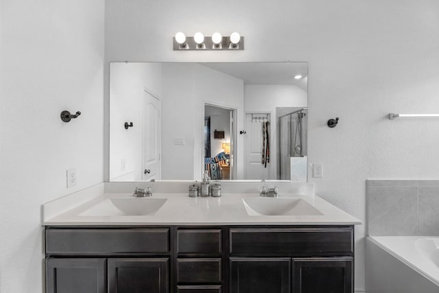 full bath featuring a sink, a shower stall, a bath, and double vanity