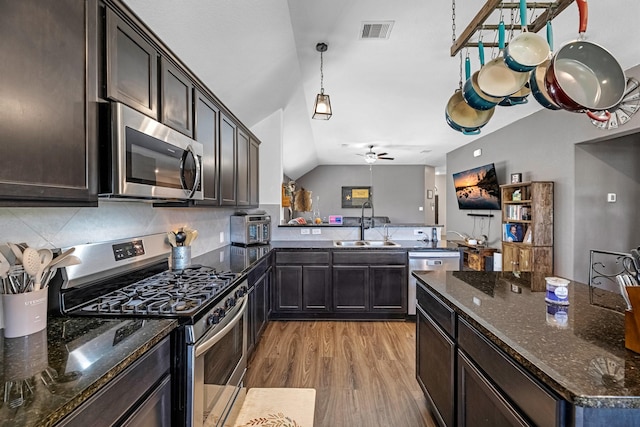 kitchen with visible vents, light wood-style flooring, a sink, stainless steel appliances, and tasteful backsplash