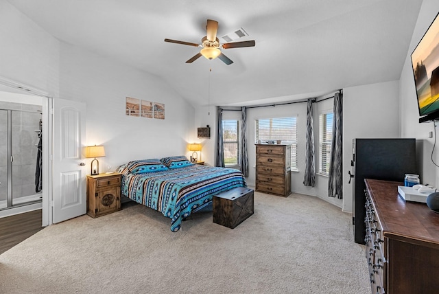 carpeted bedroom with visible vents, ceiling fan, and vaulted ceiling