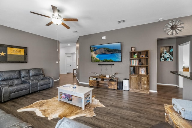 living room featuring visible vents, a ceiling fan, baseboards, and wood finished floors