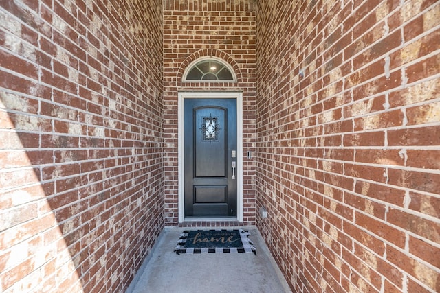 entrance to property featuring brick siding