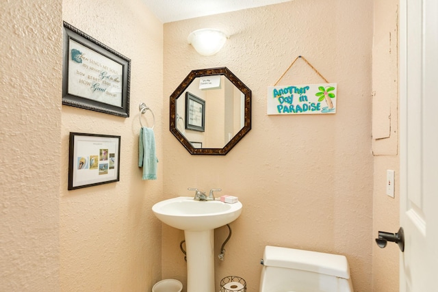 half bathroom featuring toilet and a sink