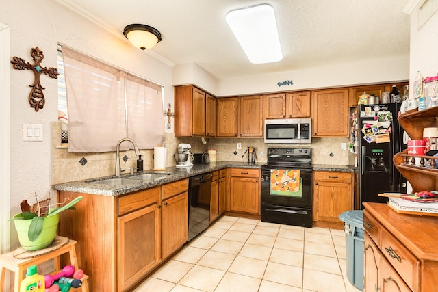 kitchen featuring black appliances, brown cabinetry, tasteful backsplash, and a sink