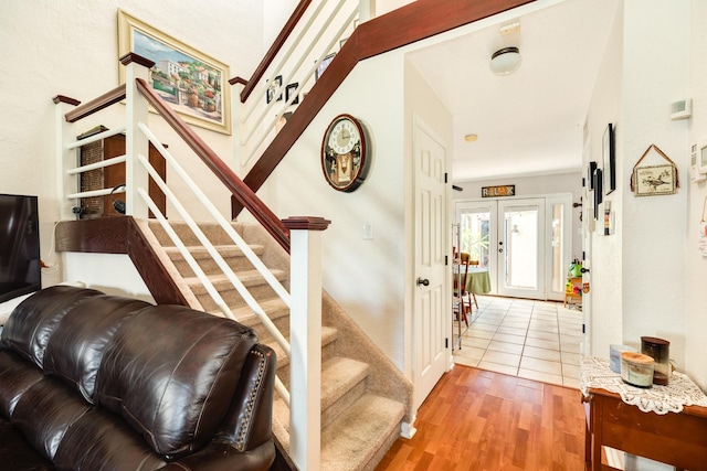 stairs with french doors and wood finished floors