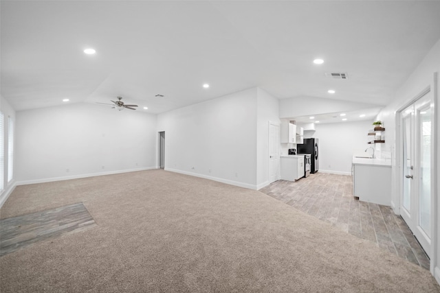 unfurnished living room with visible vents, recessed lighting, light colored carpet, and vaulted ceiling