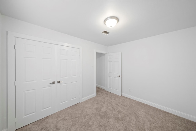 unfurnished bedroom featuring a closet, carpet floors, and baseboards