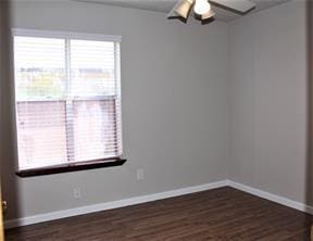 unfurnished room with baseboards and dark wood-type flooring