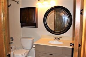 bathroom featuring tub / shower combination, toilet, and vanity