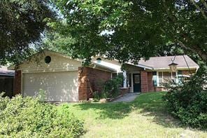 single story home featuring an attached garage, driveway, and a front lawn