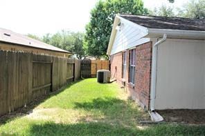 view of yard with central air condition unit and a fenced backyard