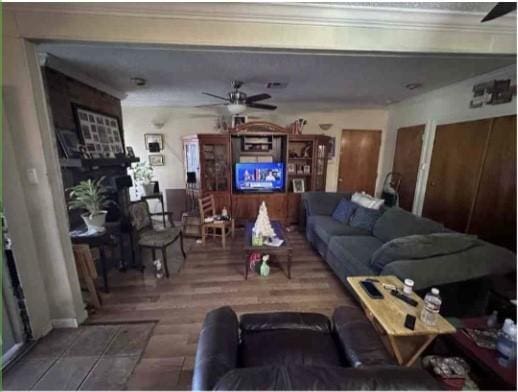 living room featuring a ceiling fan, wood finished floors, and a fireplace