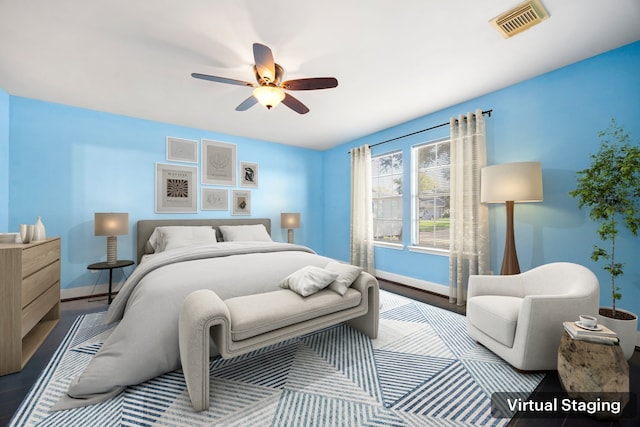 bedroom featuring visible vents, baseboards, wood finished floors, and a ceiling fan