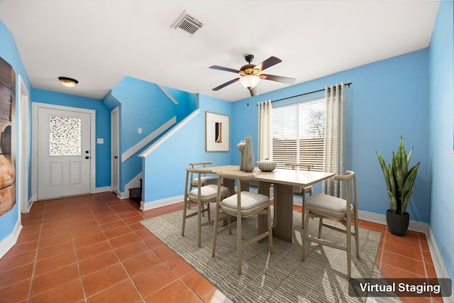 tiled dining space featuring stairs, visible vents, baseboards, and a ceiling fan