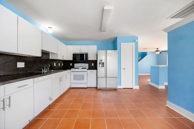 kitchen with white appliances, light tile patterned floors, visible vents, decorative backsplash, and dark countertops