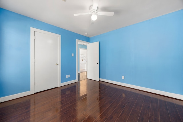 unfurnished bedroom with a ceiling fan, wood finished floors, and baseboards