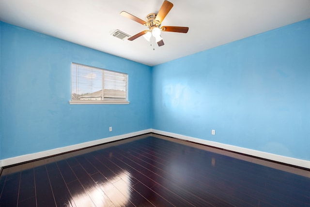 empty room featuring visible vents, a ceiling fan, baseboards, and wood finished floors