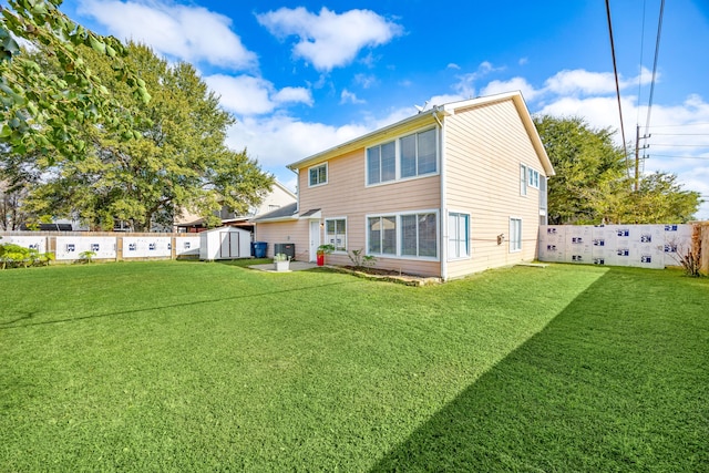 rear view of house with a storage shed, an outbuilding, a lawn, and a fenced backyard