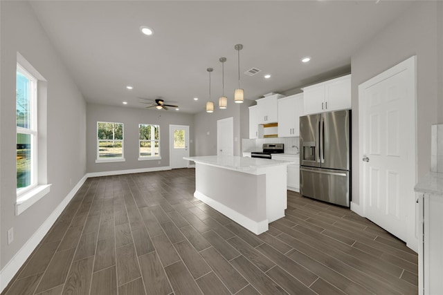 kitchen with visible vents, wood finish floors, open floor plan, appliances with stainless steel finishes, and white cabinets