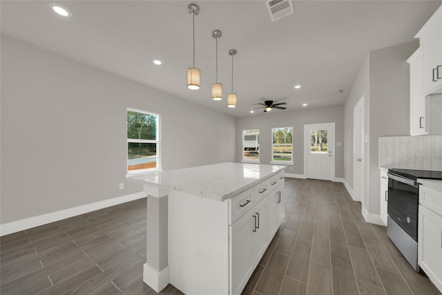 kitchen featuring stainless steel electric stove, a healthy amount of sunlight, visible vents, and wood tiled floor