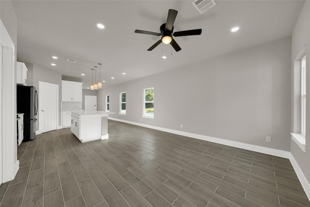 kitchen featuring visible vents, dark wood-style floors, open floor plan, freestanding refrigerator, and light countertops