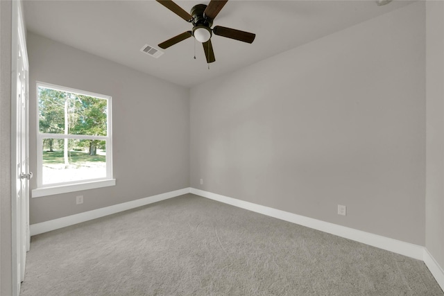 unfurnished room with a ceiling fan, visible vents, carpet, and baseboards