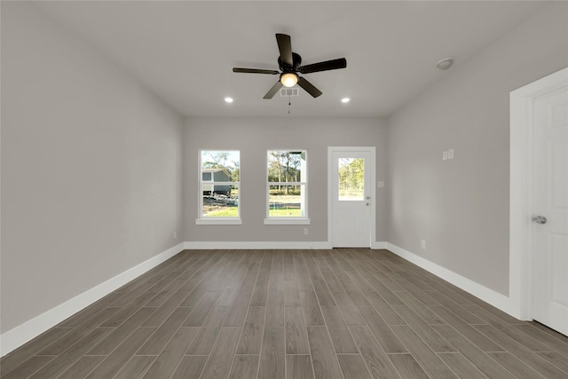 spare room featuring wood finish floors, baseboards, a ceiling fan, and recessed lighting