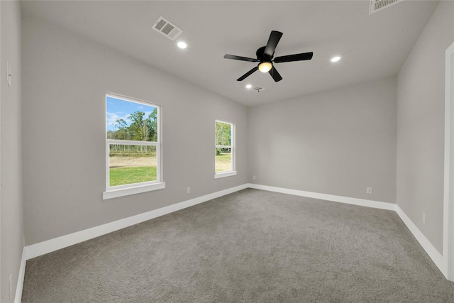 empty room featuring visible vents, a ceiling fan, recessed lighting, dark colored carpet, and baseboards