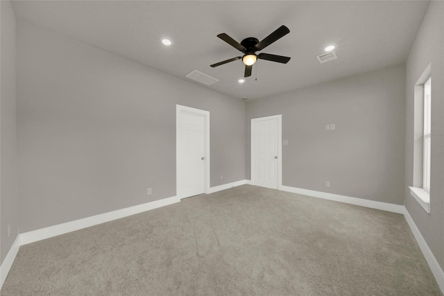 carpeted empty room featuring recessed lighting, visible vents, and baseboards