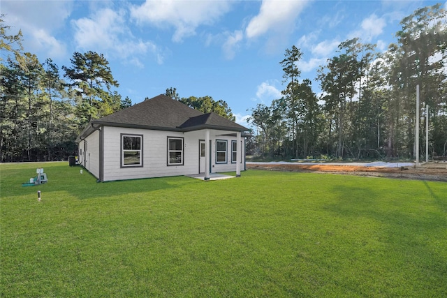 view of front of home with roof with shingles and a front yard