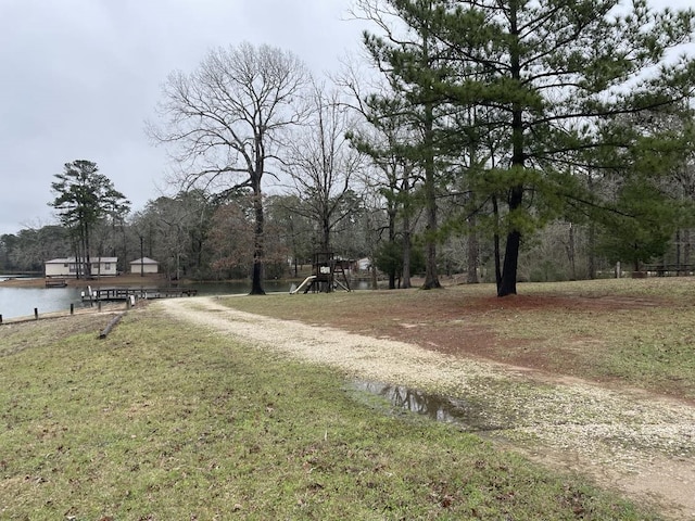 view of yard with playground community and a water view