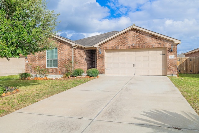 ranch-style house with fence, an attached garage, concrete driveway, a front lawn, and brick siding