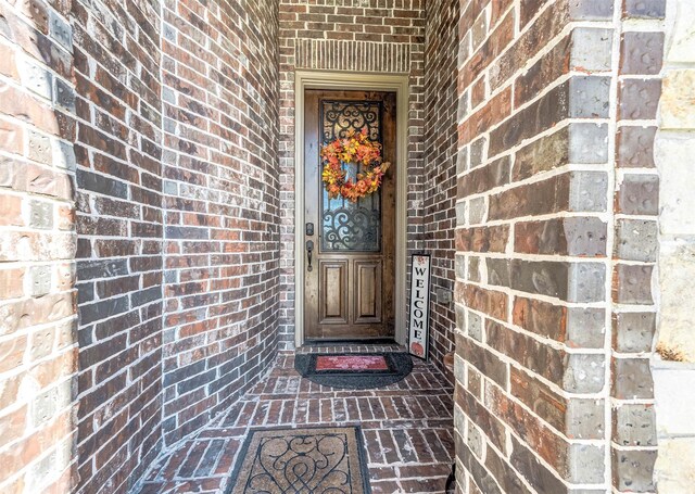 entrance to property featuring brick siding