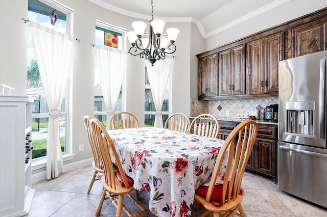 dining room featuring light tile patterned floors, baseboards, an inviting chandelier, and ornamental molding