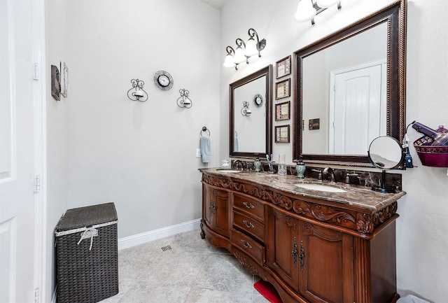 full bathroom featuring double vanity, tile patterned flooring, baseboards, and a sink