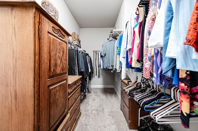 spacious closet featuring light colored carpet