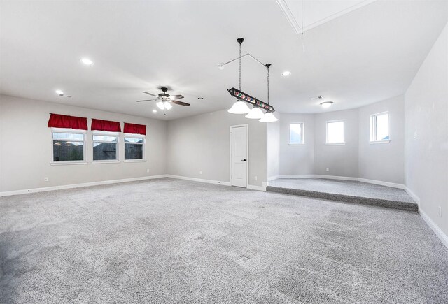 unfurnished room featuring attic access, carpet, baseboards, and a ceiling fan