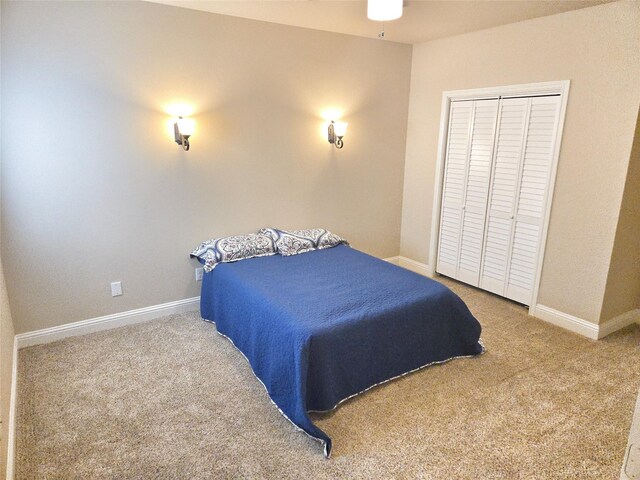 carpeted bedroom with a closet and baseboards