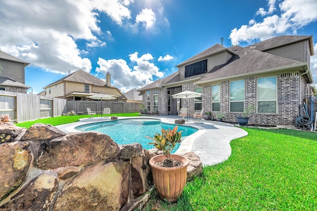 view of swimming pool with a patio, a lawn, a fenced in pool, and a fenced backyard