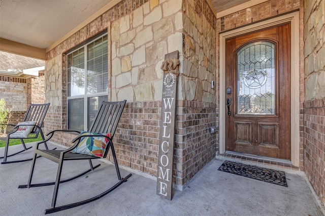 property entrance with brick siding and covered porch