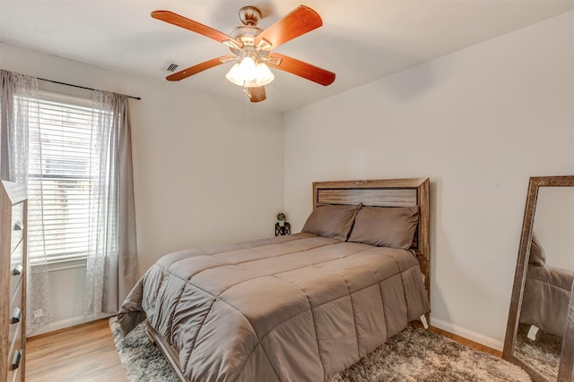 bedroom with visible vents, baseboards, multiple windows, and light wood-type flooring