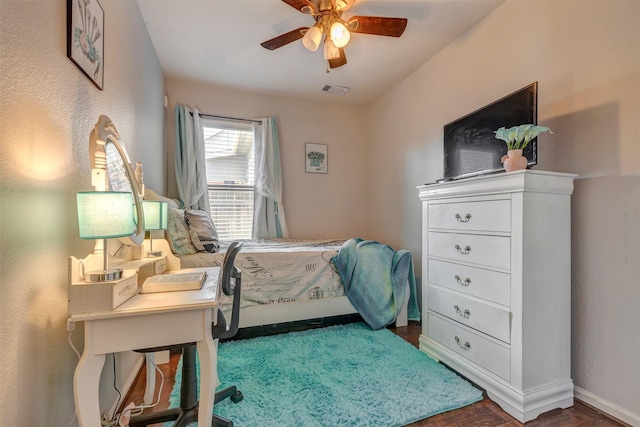 bedroom with a ceiling fan, baseboards, visible vents, and wood finished floors