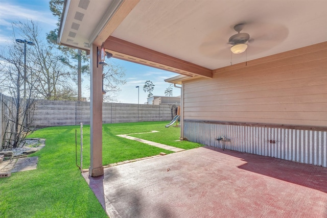 view of patio / terrace with a fenced backyard, a ceiling fan, and a playground