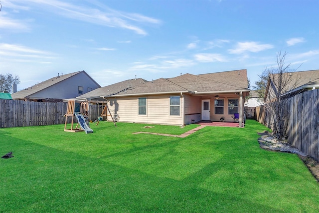 rear view of house featuring ceiling fan, a fenced backyard, a patio area, a playground, and a yard