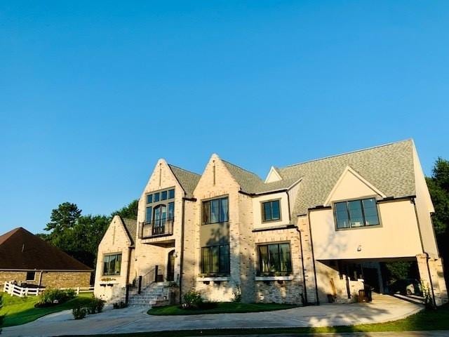 view of front of house with a carport, a balcony, driveway, and stucco siding