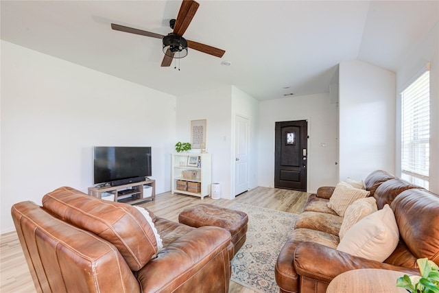 living area with light wood-type flooring, lofted ceiling, and ceiling fan