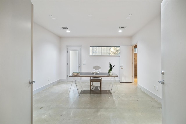 office space featuring baseboards, visible vents, and concrete flooring