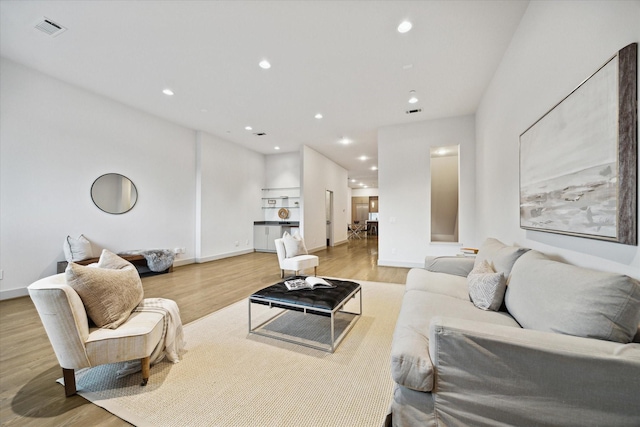 living room featuring recessed lighting, wood finished floors, visible vents, and baseboards