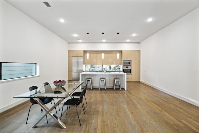 dining area with visible vents, recessed lighting, light wood-style floors, and baseboards